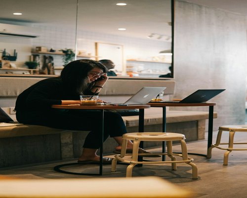 Woman taking a short standing break next to her office desk in Jakarta